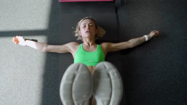 Sportlerin auf der Gymnastikmatte beim Bauchtraining im Fitnessstudio. muskulöse Athletin beim Bauchmuskeltraining. — Stockvideo