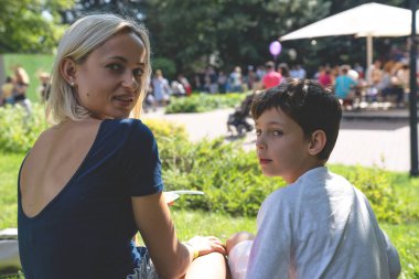 Anne ve oğlu parkta sokak yemek yeme portresi.