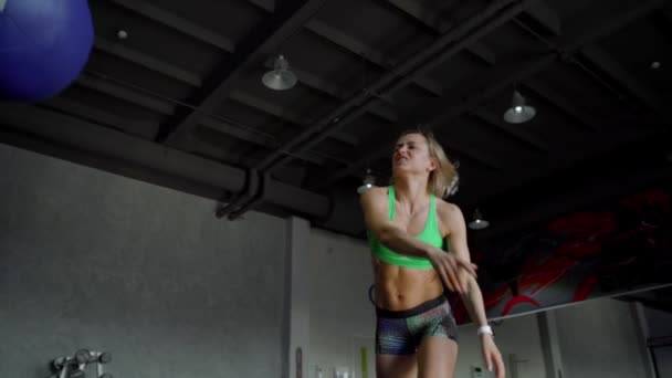 Güçlü olan kadın mükemmel fitness vücut içinde spor salonunda sağlık topu ile egzersiz. CrossFit eğitim yaparken kız. Ağır çekim. Yakın çekim — Stok video