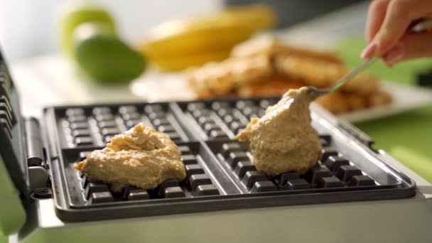 Una mujer deportiva cocinando deliciosos gofres belgas de arándanos para el desayuno por la mañana en la cocina — Vídeos de Stock