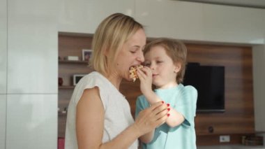 Mutfakta waffle pişirme genç kadın ve sevimli çocuk ona yardımcı olur. Sabah erken saatlerde famaly pişirme kahvaltı
