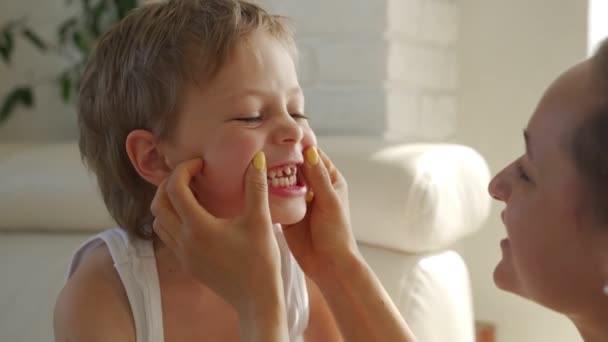 6-річний хлопчик їсть зелене яблуко і намагається витягнути зуби — стокове відео