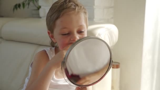Malého chlapce se světlými vlasy se zrcadlem otevírající ústa, aby ukázal, kde ztratil jednu ze svých blátiví zubů — Stock video