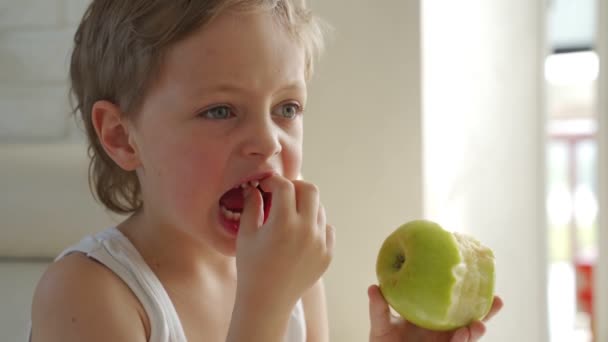 6 anos de idade menino comendo maçã verde arrancado dente primário — Vídeo de Stock