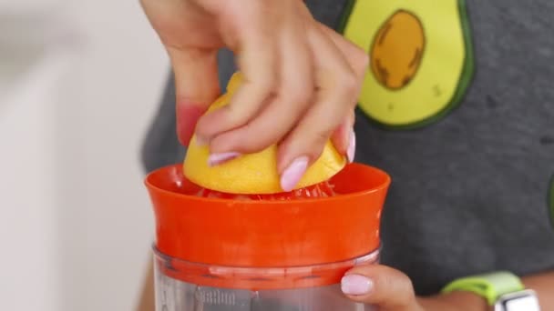 Ruční stlačování čerstvého citronu. Citronová šťáva odtéká z buničiny a kapky. — Stock video