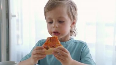 Evde pizza yiyen iki beyaz çocuk. Gün ışığı