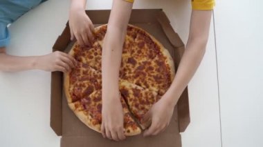 Evde pizza yiyen iki beyaz çocuk. Gün ışığı