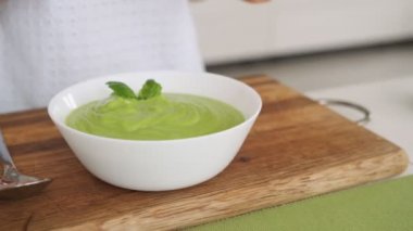 Yeşil avokado çorbası pişiren kadın. Sağlıklı pişirme konsepti