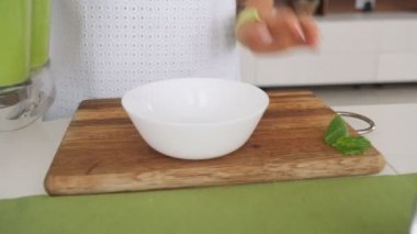 Yeşil avokado çorbası pişiren kadın. Sağlıklı pişirme konsepti