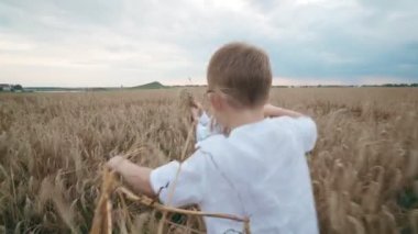 Genç anne ve çocuk oğlu küçük sevimli çocuk ile birlikte güzel kadın eğlenmek sarılma bir buğday tarlasında yalan.