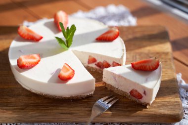 Beyaz arkaplanda bir dilim çilekli cheesecake, seçici odak, kare resim.