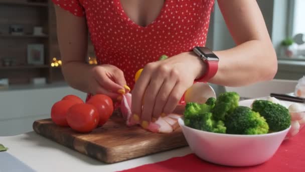 Vrouw die de salade maakt met gesneden spek en groenten — Stockvideo