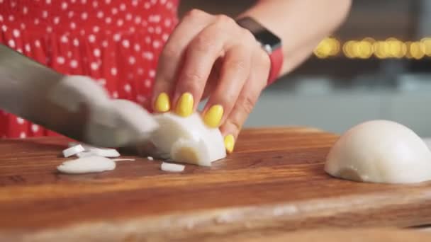 Gros plan d'une femme coupant des légumes sains sur une planche à découper en bois dans une cuisine moderne avec un gros couteau — Video