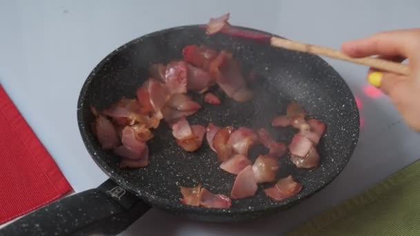 Hakket bacon stekt i en varm stekepanne – stockvideo