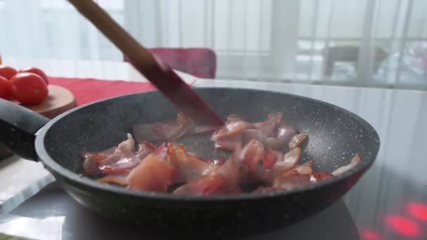 Hakket bacon stekt i en varm stekepanne – stockvideo