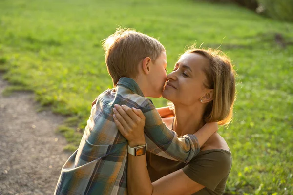 Vacker ung mor med liten son promenader i parken efter ett regn — Stockfoto