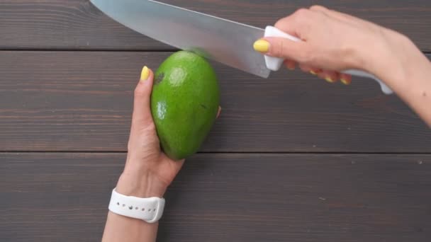 Aguacate verde de corte abierto de manos femeninas, vista en primera persona — Vídeo de stock