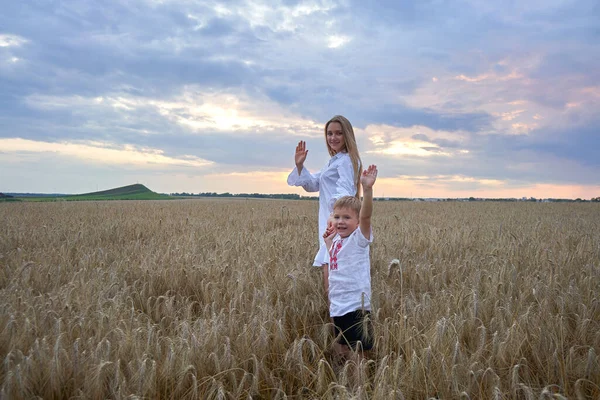 행복 한 어머니 와아들 이 밀밭을 헤쳐 나가고 있다. — 스톡 사진