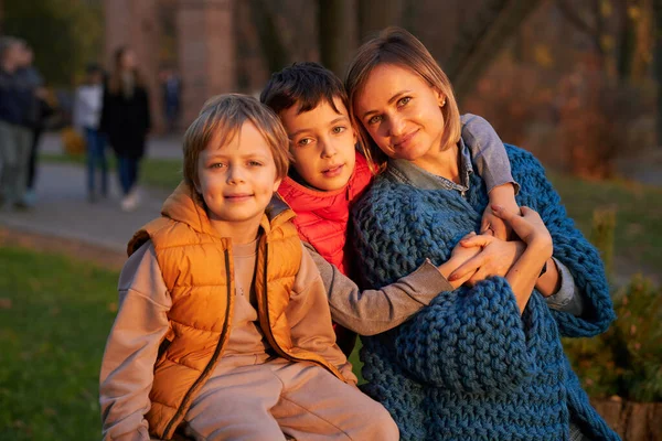 Счастливая мама с двумя мальчиками на осенней прогулке . — стоковое фото