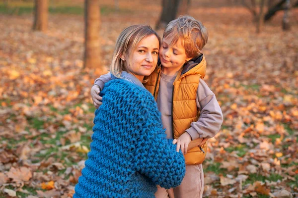 Heureux famille mère et bébé fils sur la marche d'automne. — Photo