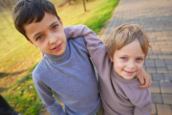 Dois meninos da escola pouco ativa abraçando no dia de outono . — Fotografia de Stock