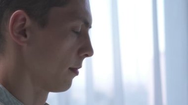 Genç adam ofiste dizüstü bilgisayarla çalışırken çikolata yiyor. Kapat.