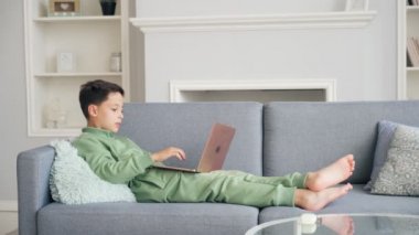 Video çağrısı. Uzaklık Eğitimi. Öğrenci videosu laptop aracılığıyla annemle konuşuyor. Bilgisayar kullanarak çocuk videosuyla konuşmak. Ev Konferansı Çocuk Eğitimi.