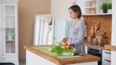 Anne ve oğul kahvaltı hazırlıyorlar. Anne, oğlu için mutfakta sandviç yapıyor.