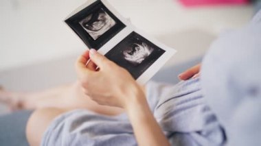 Güzel hamile kadın, elinde ultrason bebek resmi tutuyor. Hamile kadın ve annelik sağlığı konsepti