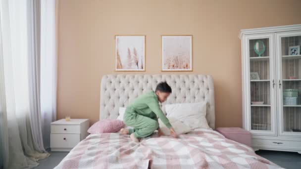 Kaukaski chłopiec skoków na łóżku o zabawy śmiech zabawny aktywny gra z cute dziecko syn w sypialni. — Wideo stockowe