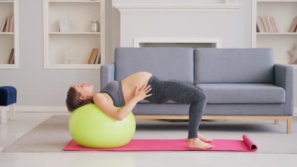 Έγκυος γυναίκα άσκηση με Pilates μπάλα σε ένα σαλόνι — Αρχείο Βίντεο