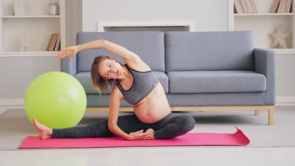 Ciężarna kobieta Ćwiczenia z Pilates Ball w salonie — Wideo stockowe