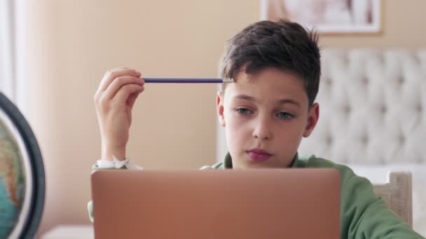 Little boy during COVID-19 quarantine attending to online school class from his room — Stock Video