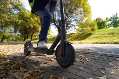 Sırt çantalı öğrenci okula elektrikli scooterla gidiyor..