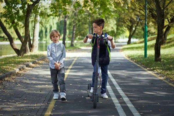 Sırt çantalı öğrenci okula elektrikli scooterla gidiyor..