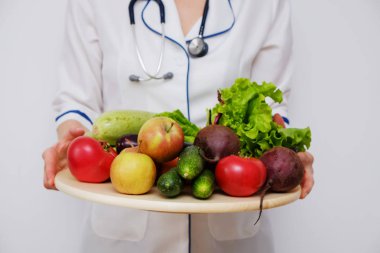 Bir tabak meyve ve sebze ile tutan doktor