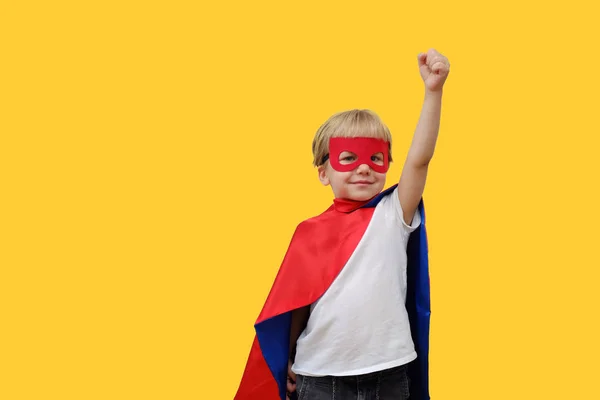 Lindo chico en traje de superhéroe sobre fondo amarillo — Foto de Stock