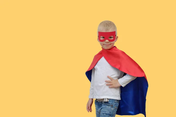 Roztomilý chlapec v kostýmu superhrdiny na žlutém podkladu — Stock fotografie