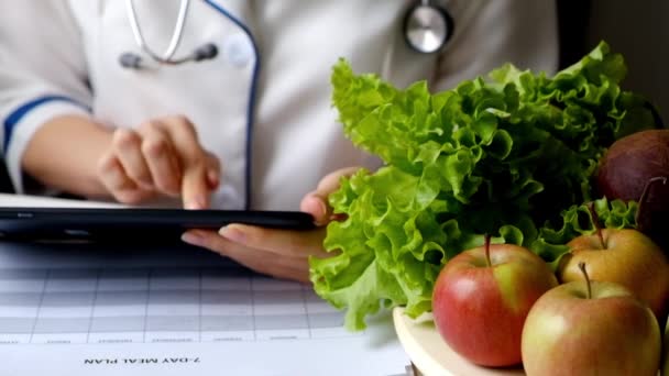 Nutricionista mulher escrevendo plano de dieta usando tablet PC — Vídeo de Stock