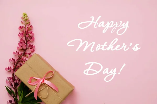 Çiçek ve hediye pembe bir arka plan üzerinde kompozisyonu. Tebrik kartı-mutlu anneler günü. Düz yatıyordu.