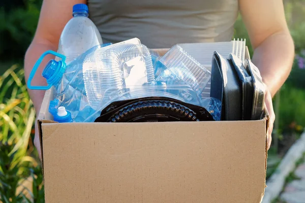 Bir karton geri dönüşüm plastik çöp ile holding eller mans. Geri dönüşüm kavramı