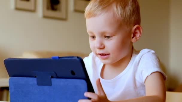 Маленький мальчик играет с планшетным ПК — стоковое видео