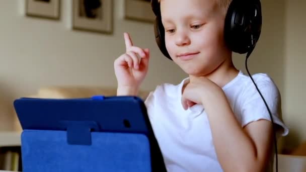 Liten pojke leker med Tablet Pc bär hörlurar — Stockvideo