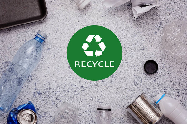 Eco concept with recycling symbol and garbage on table background top view
