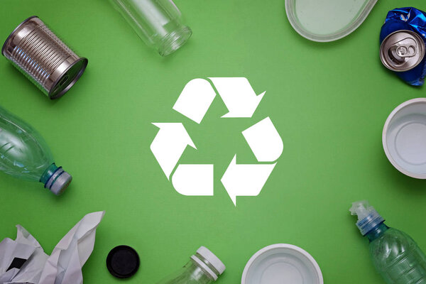 Eco concept with recycling symbol and garbage on table background top view