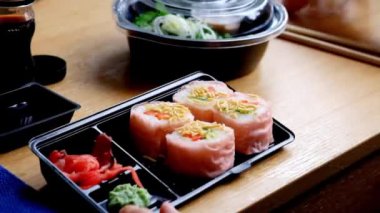 Teslimat gıda kavramı: Plastik sofra üzerinden suşi yemek kadın