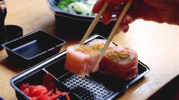 Levering voedsel concept: vrouw eten sushi van kunststof servies — Stockvideo