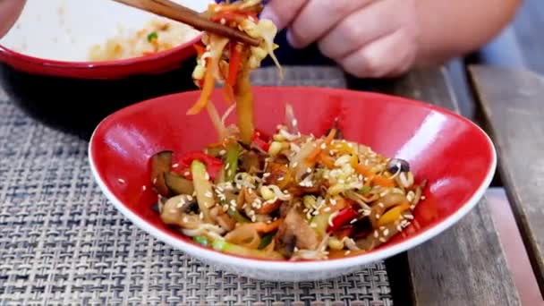 Hombre comiendo arroz con verduras en un reastaurante chino — Vídeos de Stock