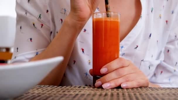 Mujer bebiendo jugo fresco de zanahoria en un café, de cerca — Vídeos de Stock