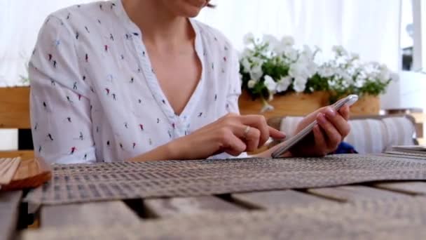 Smartphone de mano femenina, en un café o restaurante — Vídeos de Stock